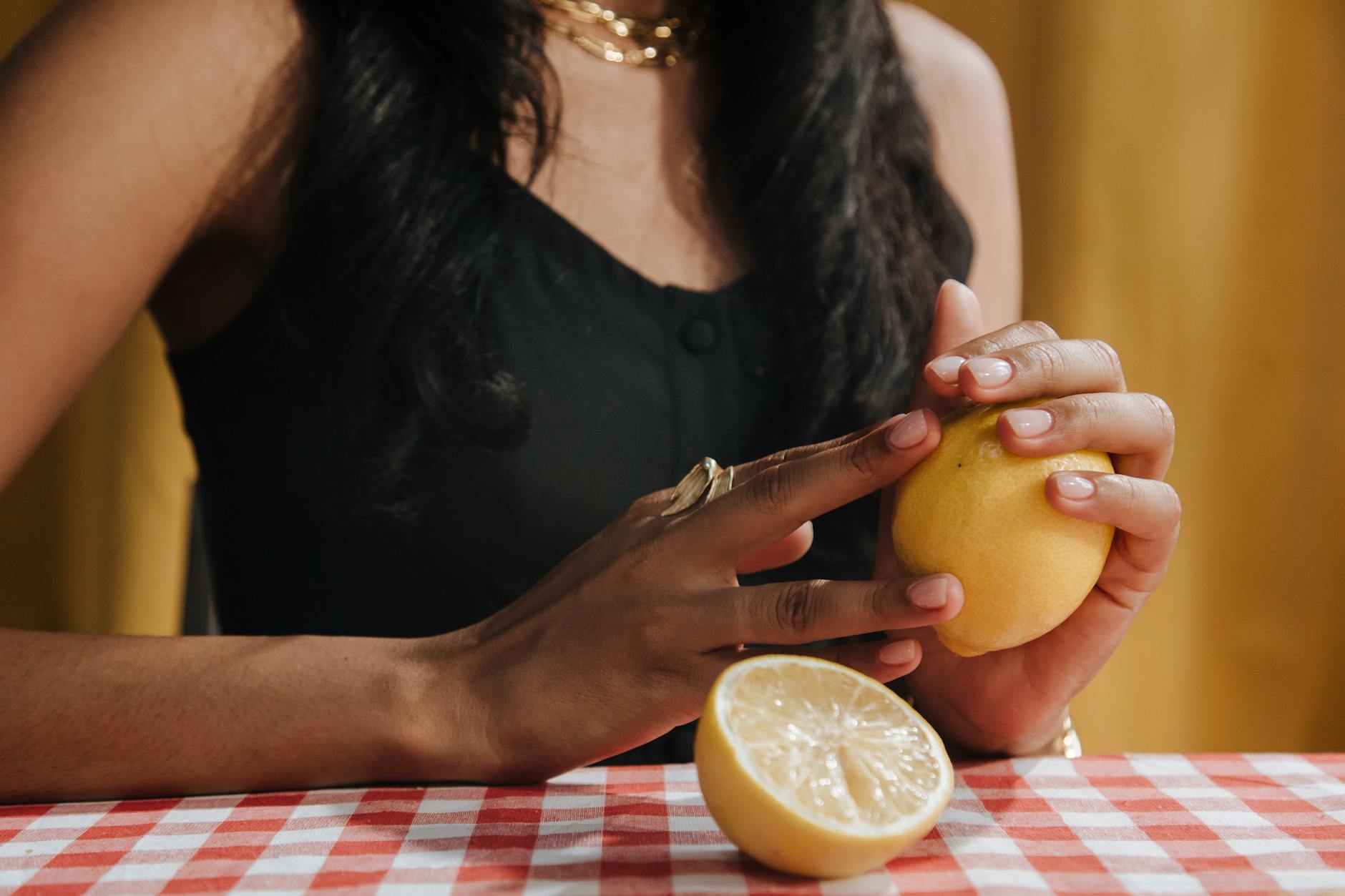 Close-up of hands holding a fresh lemon.