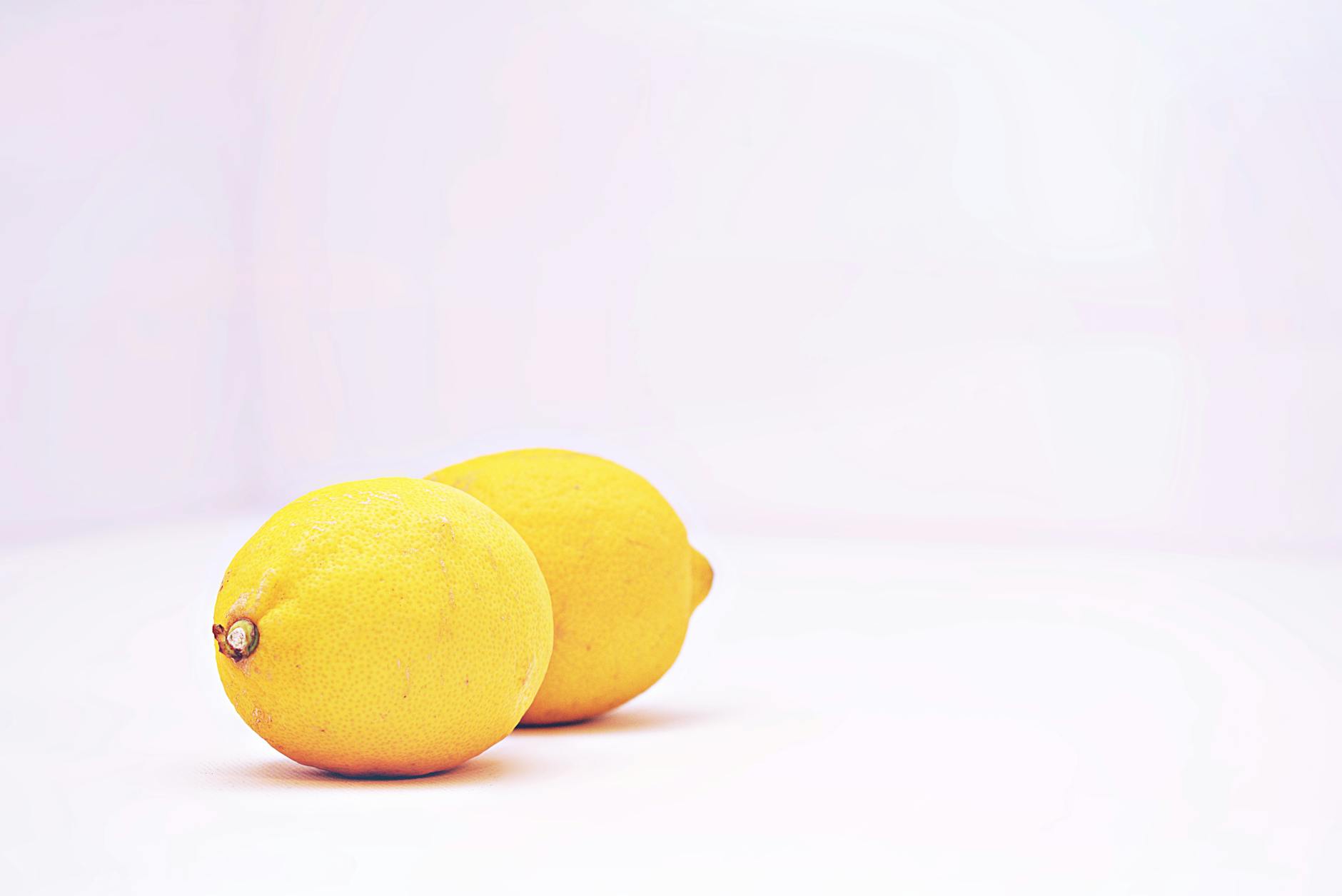 Fresh lemons on a white background, symbolizing the bright, accessible design of lemon vibrators