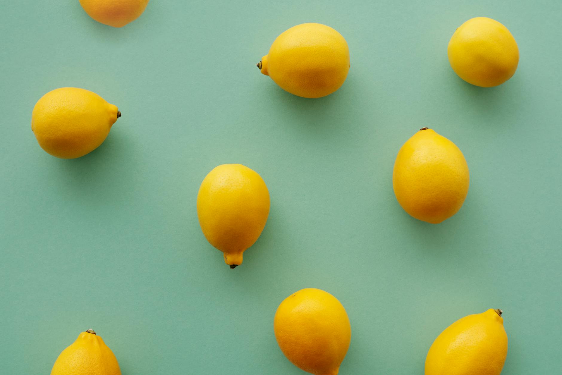 Bright yellow lemons arranged on a soft pastel background, symbolizing fresh approaches to shared pleasure