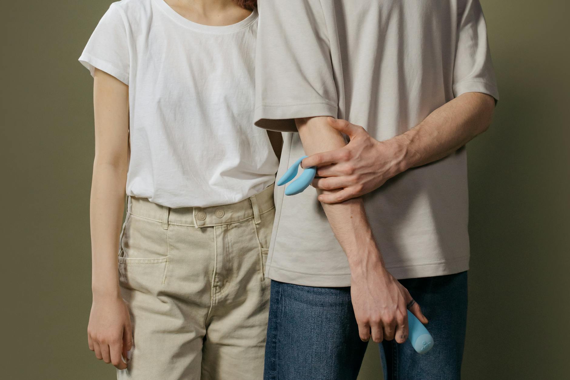A couple standing together indoors, exploring intimacy with a modern vibrator
